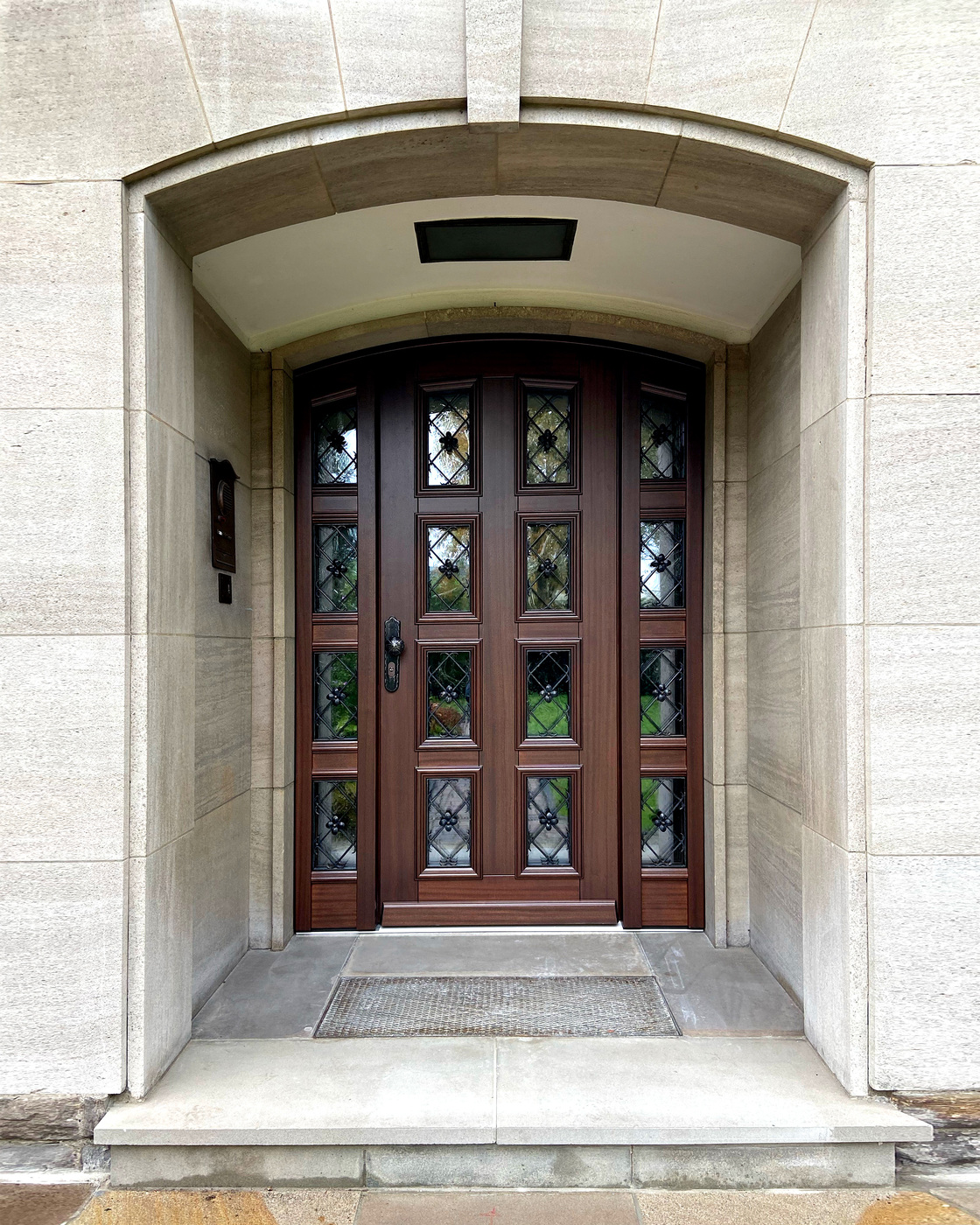 Holztür mit Glasfenstern in einem Steineingang, braun und elegant designt