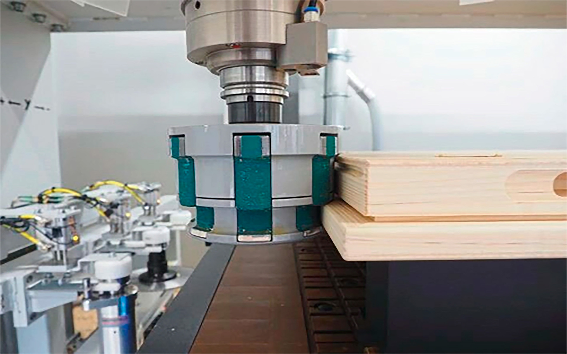 Eine CNC-Maschine verarbeitet präzise ein Holzbrett mit einem grün-silbernen Fräser.