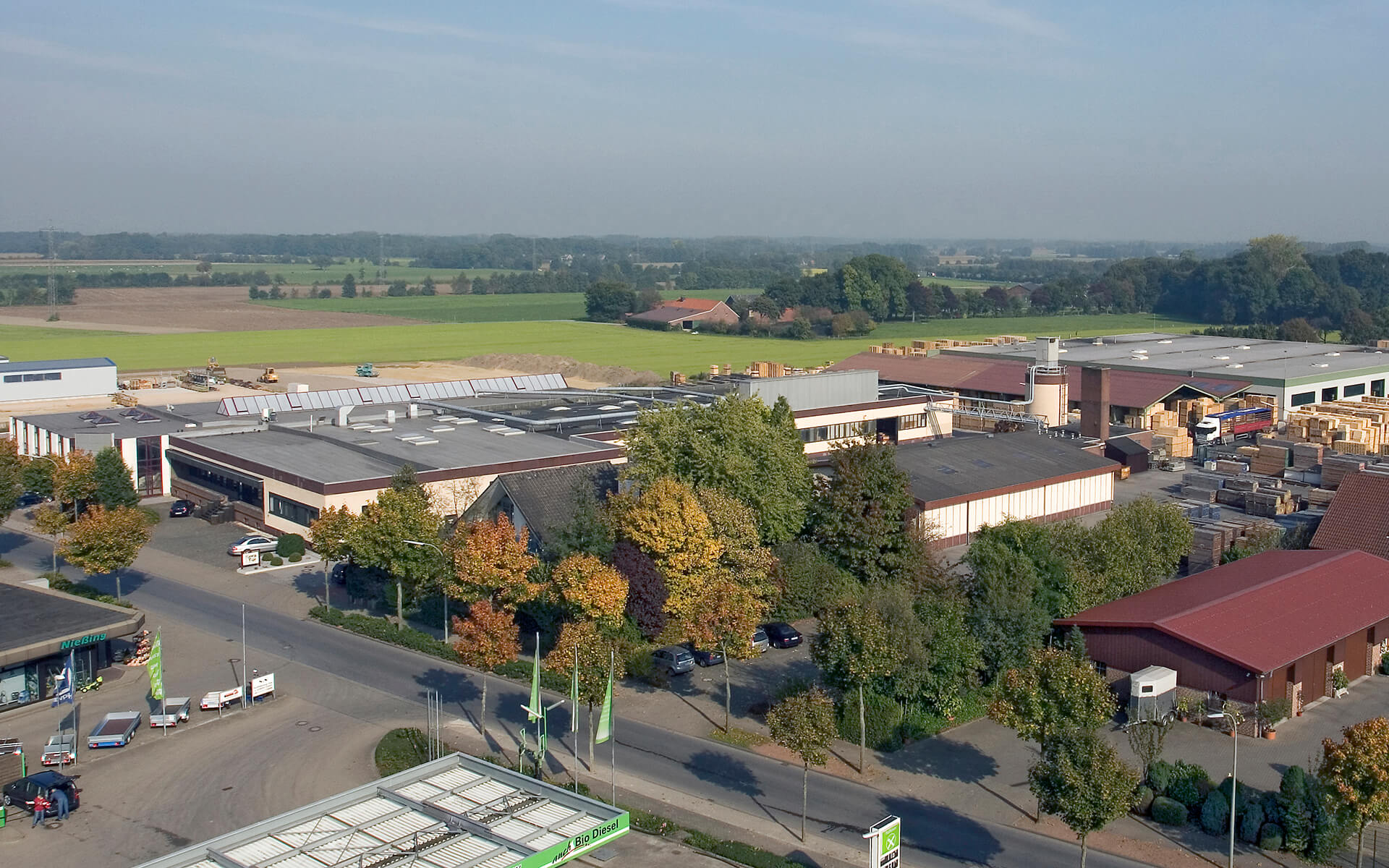 Eine Industrieanlage mit umliegenden Bäumen und Feldern im Hintergrund