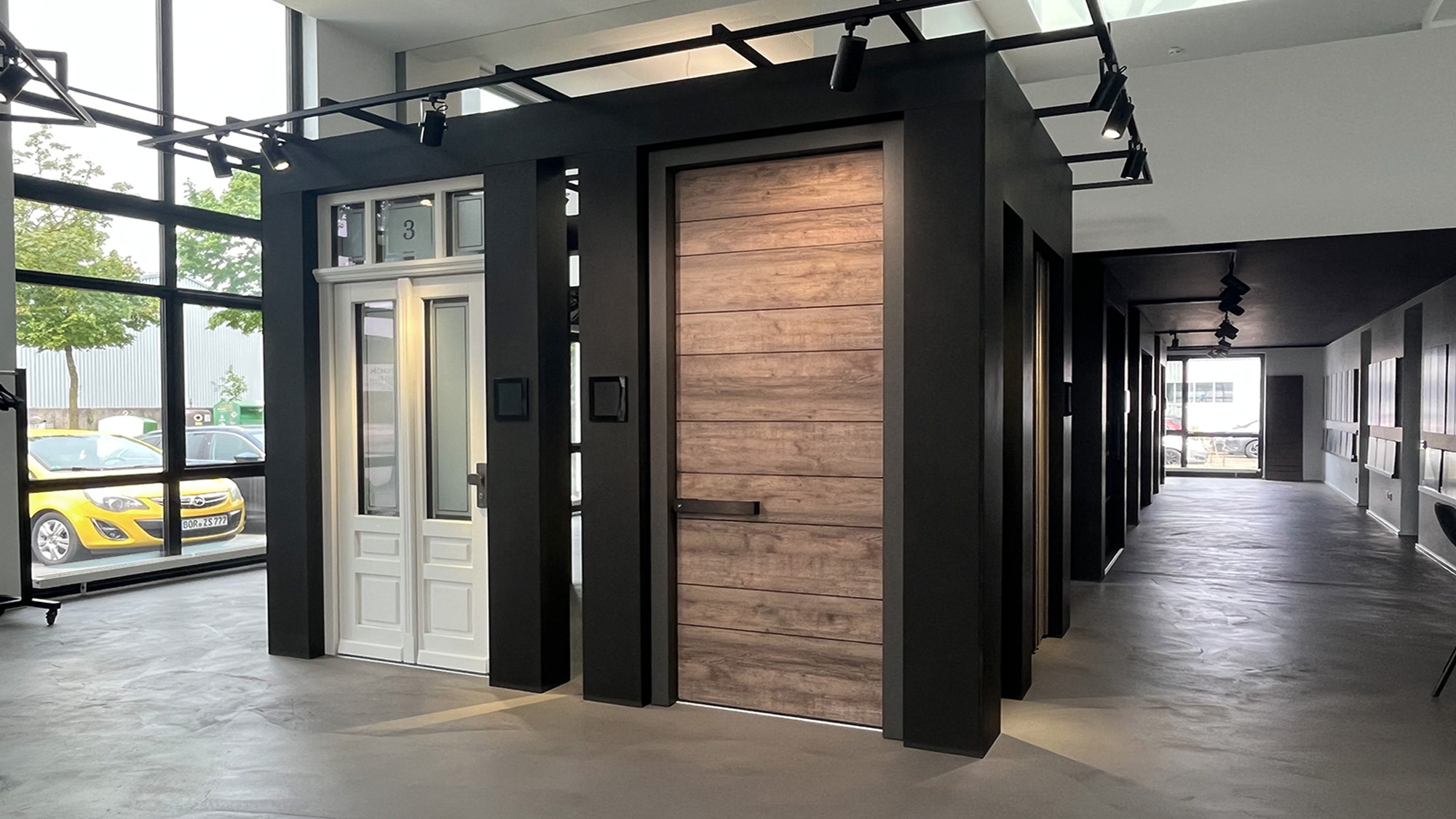 Modernes Interieur mit weißer Tür und großer Holzschiebetür in Schwarzgrau