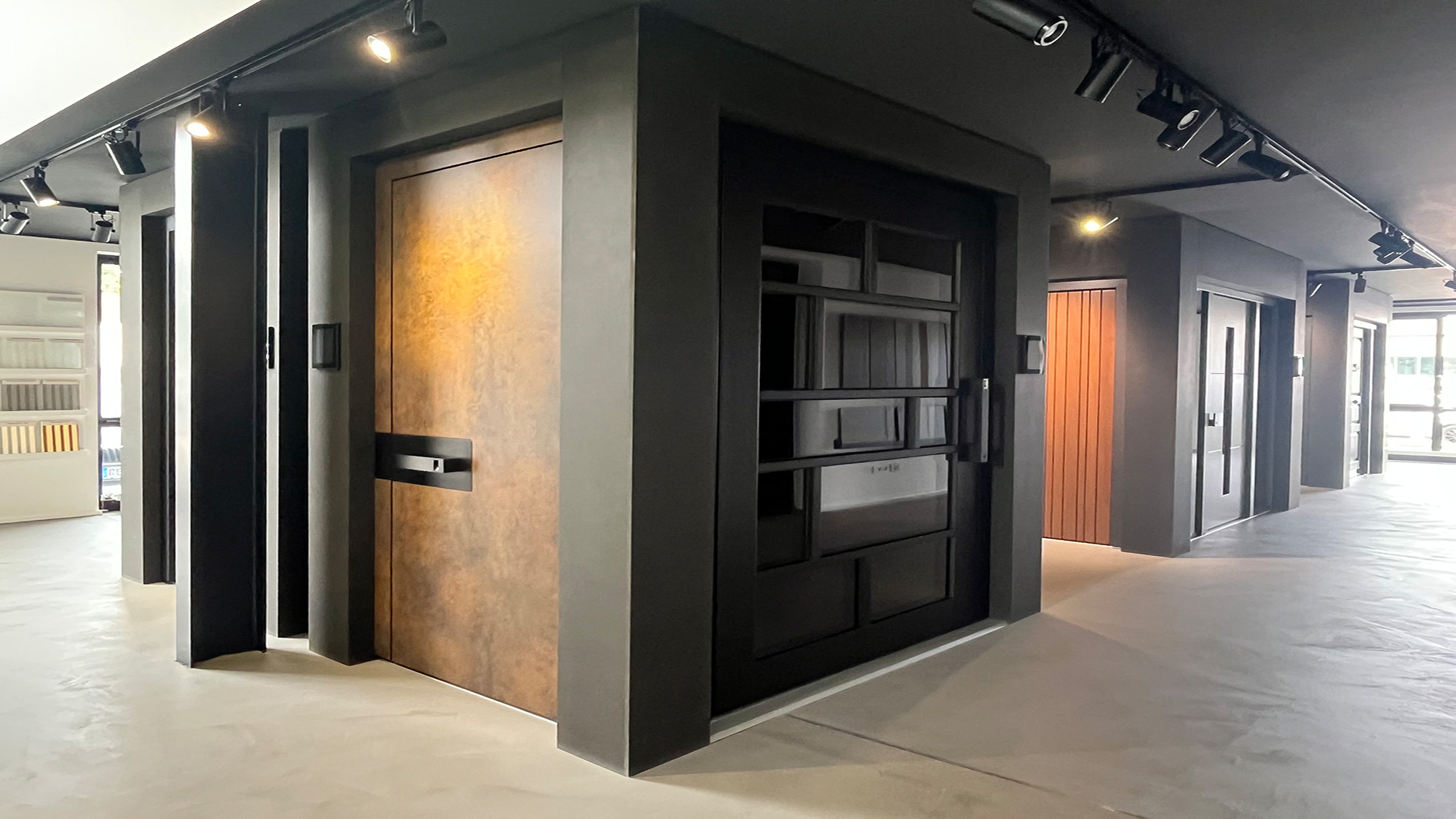 Moderner Showroom mit schwarzen Wänden und rostfarbener Tür im Fokus