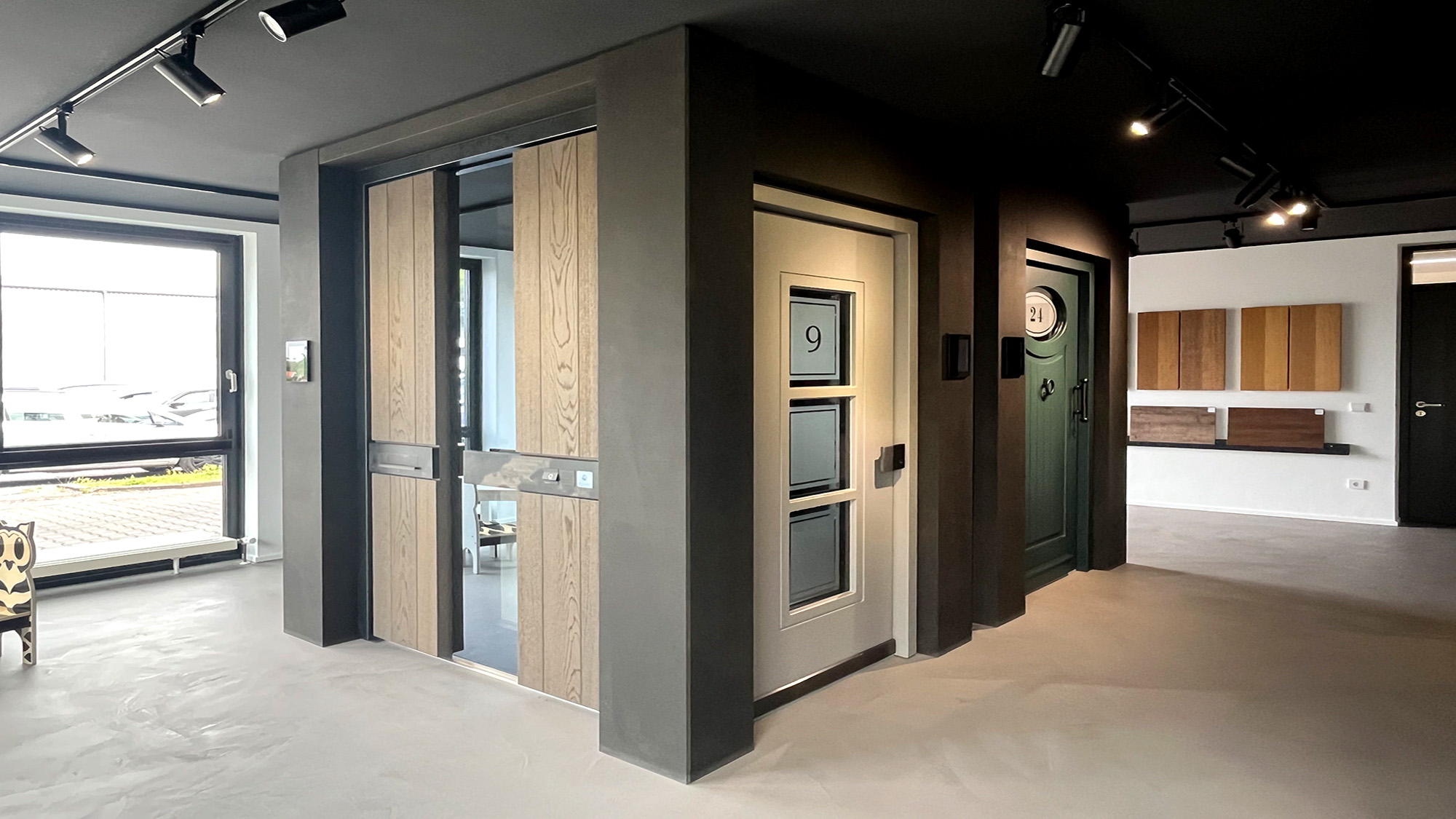 Moderner Showroom mit grauen Wänden und Holz Glastüren sowie Spots