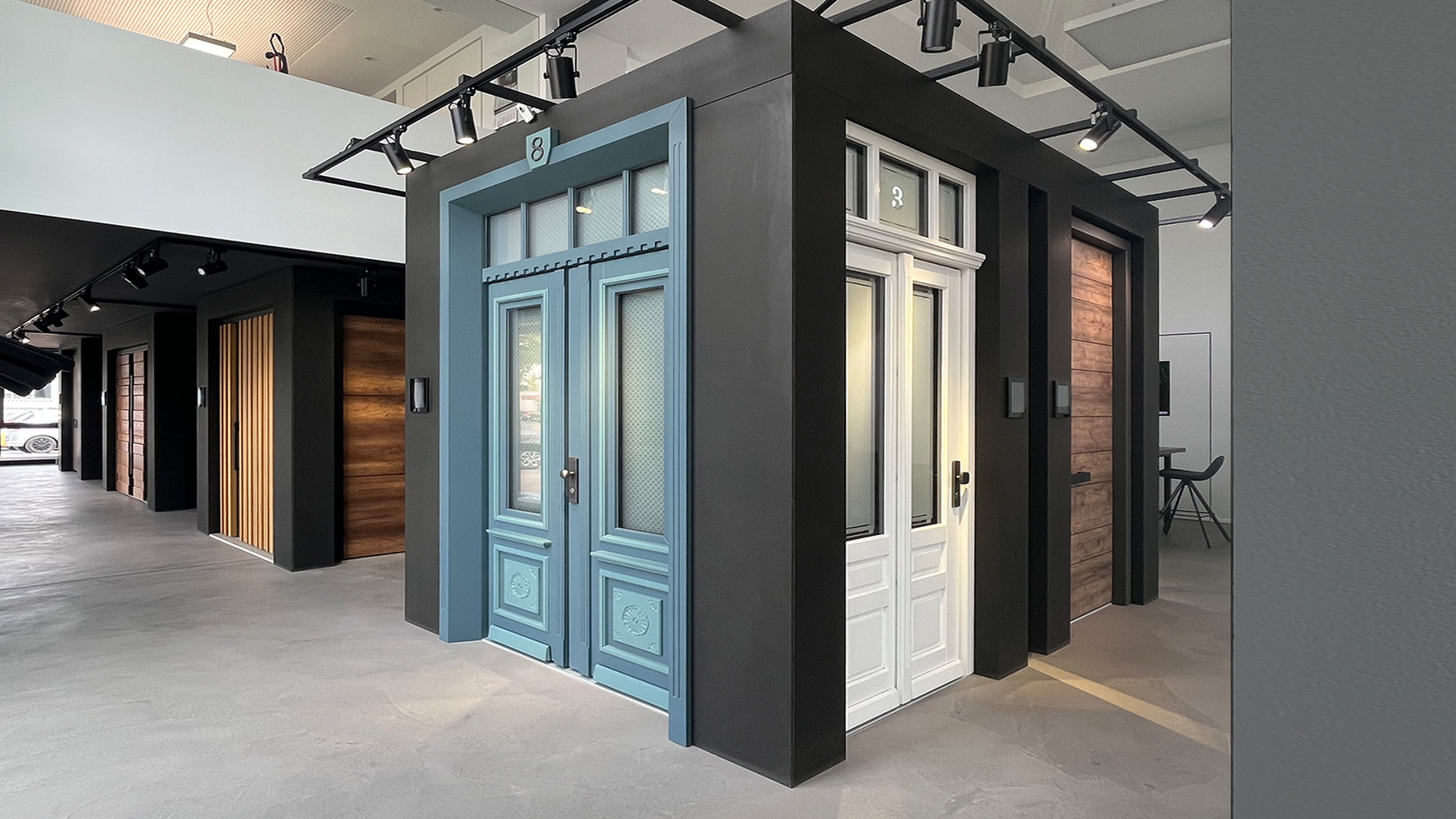 Ausstellung moderner Haustueren in Blau und Weiss mit Holzpaneelen