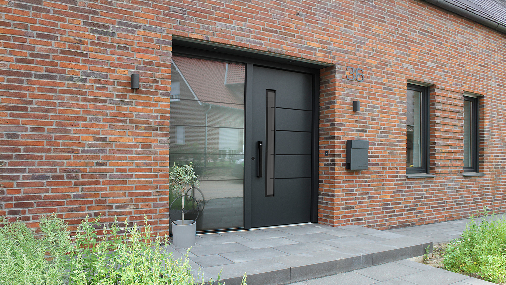 Schwarze Haustuer in roter Ziegelfassade, modern und schlicht, Nr 36